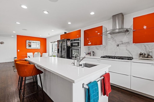 kitchen with wall chimney exhaust hood, a sink, dark wood-style flooring, recessed lighting, and black appliances