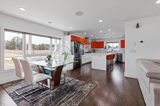 dining space with recessed lighting, dark wood finished floors, and baseboards