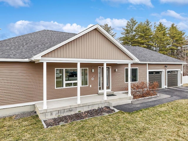 view of front of home featuring an attached garage, a shingled roof, and covered porch