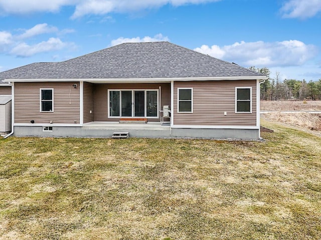 back of house featuring a lawn and a shingled roof