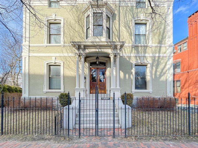 727 Congress St Unit 5, Portland, ME 04102 - view of front of home with french doors, brick siding, and a fenced front yard
