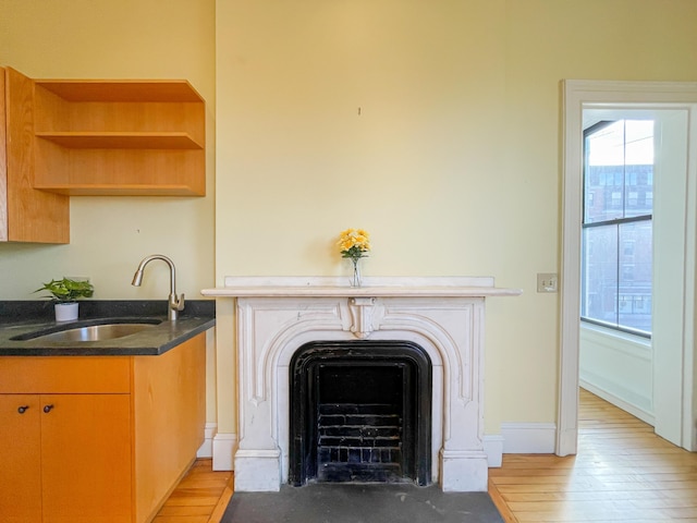 727 Congress St Unit 5, Portland, ME 04102 - room details featuring a fireplace with flush hearth, baseboards, wood finished floors, and a sink