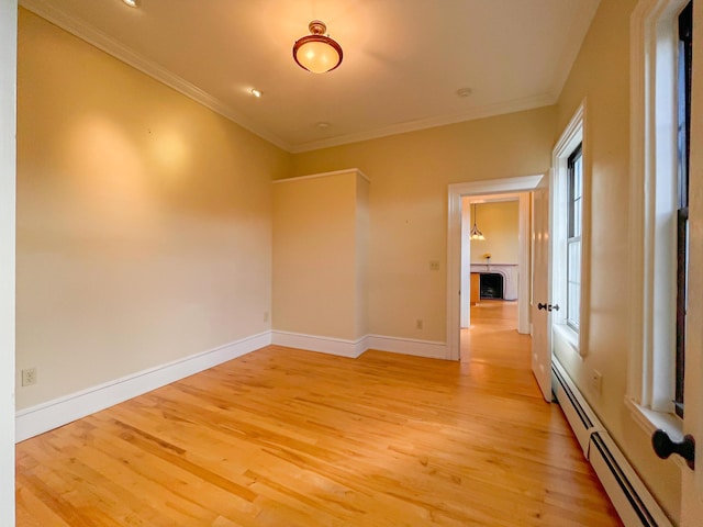 727 Congress St Unit 5, Portland, ME 04102 - empty room with light wood finished floors, baseboards, a baseboard heating unit, and ornamental molding
