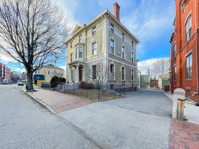 727 Congress St Unit 5, Portland, ME 04102 - view of front of house featuring a residential view, a fenced front yard, and a chimney