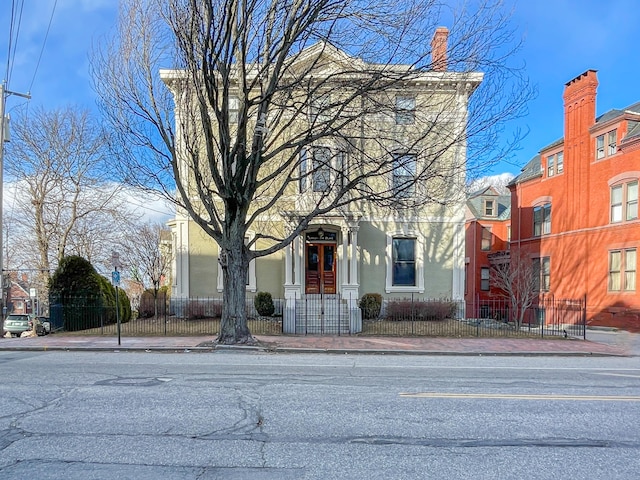 727 Congress St Unit 5, Portland, ME 04102 - view of front of house featuring a chimney, a fenced front yard, and stucco siding