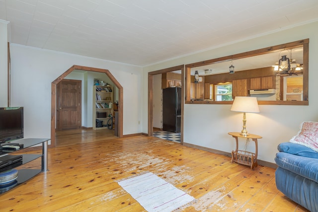 927 Pleasant St, Blue Hill, ME 04614 - living area featuring light wood-type flooring, crown molding, arched walkways, and baseboards