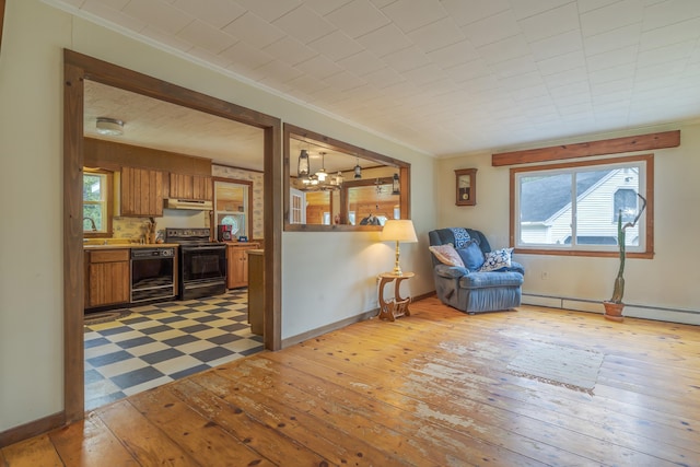 927 Pleasant St, Blue Hill, ME 04614 - living area with ornamental molding, a chandelier, baseboard heating, plenty of natural light, and baseboards
