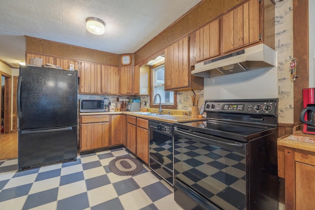 927 Pleasant St, Blue Hill, ME 04614 - kitchen with black appliances, light floors, under cabinet range hood, a sink, and brown cabinets