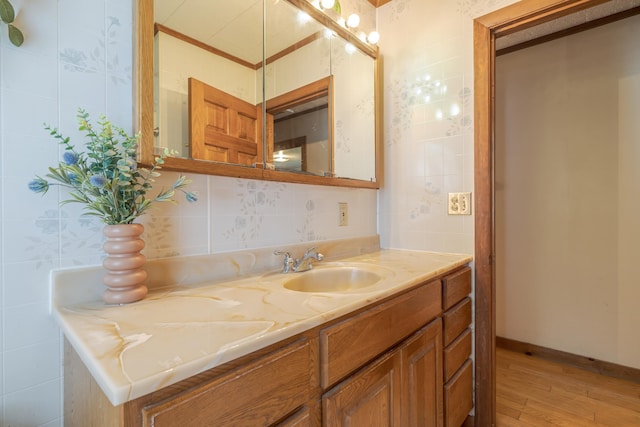 927 Pleasant St, Blue Hill, ME 04614 - bathroom with wood finished floors, vanity, decorative backsplash, and crown molding