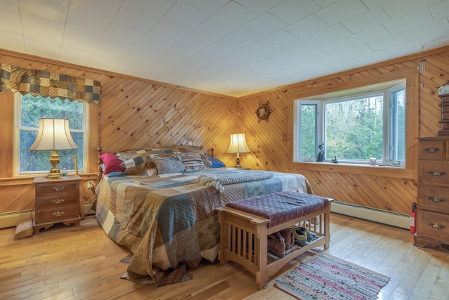 927 Pleasant St, Blue Hill, ME 04614 - bedroom with a baseboard heating unit, wood walls, and light wood finished floors