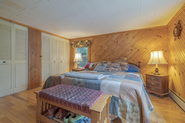 927 Pleasant St, Blue Hill, ME 04614 - bedroom featuring baseboard heating, light wood-style floors, and wood walls