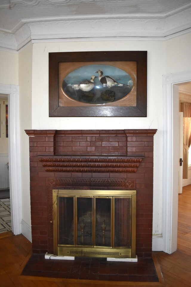 14 Central St, Winthrop, ME 04364 - detailed view of a fireplace with flush hearth, wood finished floors, crown molding, and baseboards