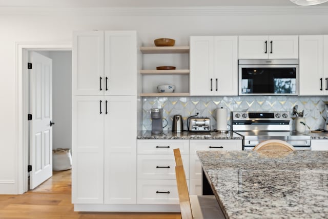 kitchen with stainless steel appliances, white cabinetry, light stone counters, and open shelves