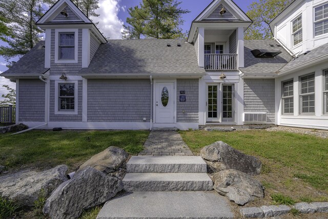 302 Eddy Rd Unit 302, Edgecomb, ME 04556 - view of front of home featuring a balcony, a shingled roof, and a front yard