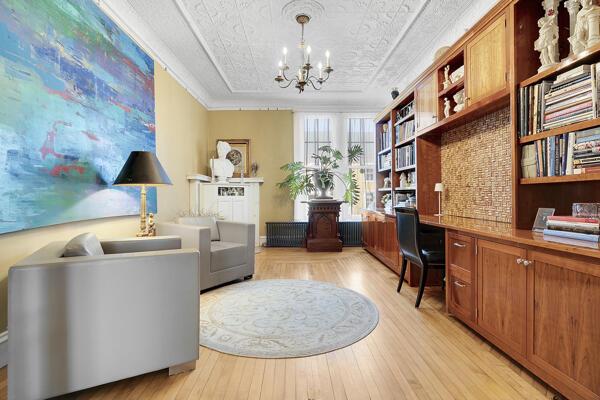sitting room featuring ornamental molding, light wood finished floors, built in desk, and a notable chandelier