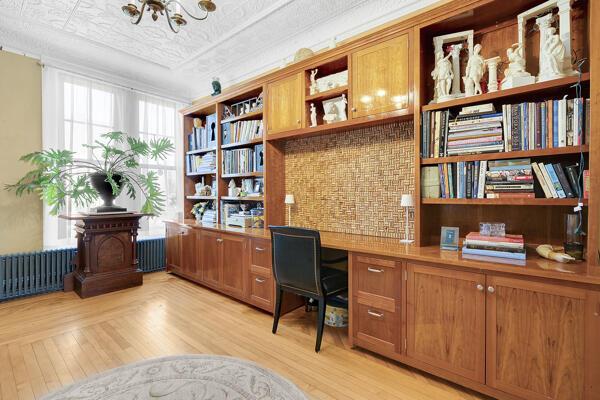 office featuring a notable chandelier, light wood finished floors, built in study area, an ornate ceiling, and radiator