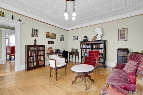 sitting room with baseboards and an ornate ceiling