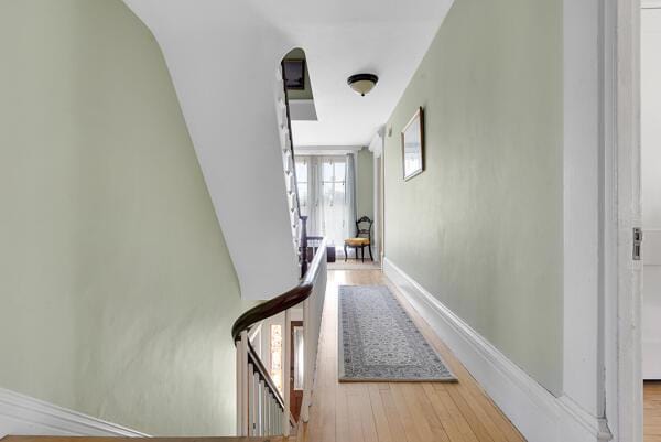 hall with baseboards and wood finished floors