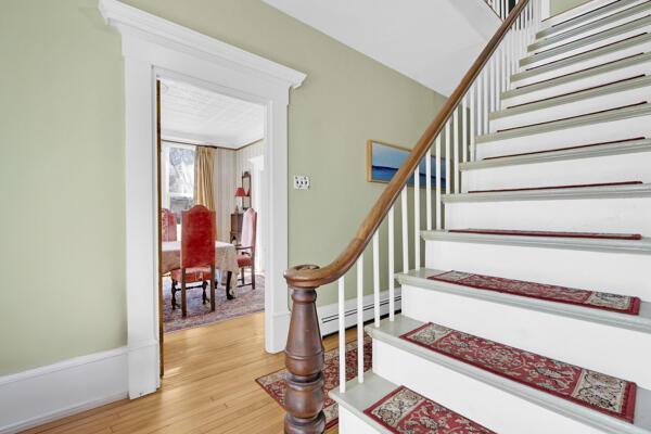 staircase featuring wood finished floors and a baseboard heating unit