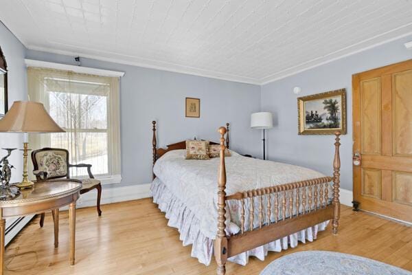 bedroom with baseboards and light wood finished floors