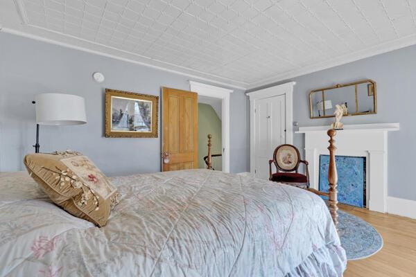 bedroom featuring wood finished floors and a fireplace