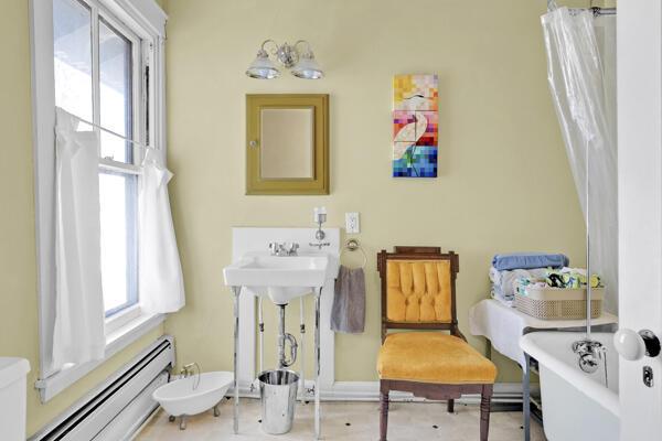 bathroom with a shower with shower curtain, baseboards, baseboard heating, and a bath
