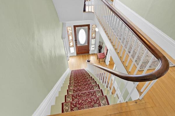stairs featuring a high ceiling and wood finished floors