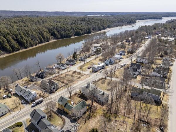 birds eye view of property with a water view and a view of trees