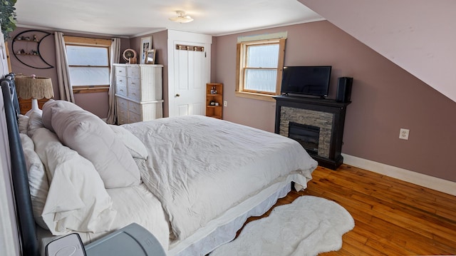 4 Burgess Rd, Guilford, ME 04443 - bedroom with a stone fireplace, baseboards, ornamental molding, and wood-type flooring