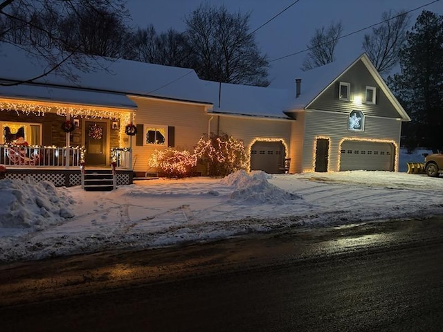 view of front of house with a porch, driveway, and a garage