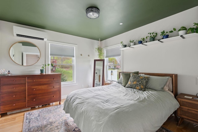 66 Evans St Unit 12, South Portland, ME 04106 - bedroom with a wall mounted AC, multiple windows, and wood finished floors