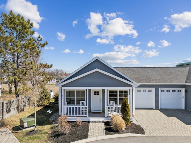 66 Evans St Unit 12, South Portland, ME 04106 - view of front facade featuring covered porch, an attached garage, driveway, roof with shingles, and fence