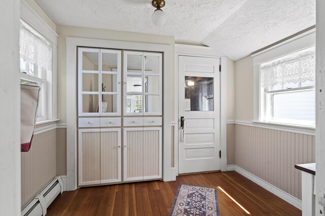 294 E Pond Rd, Jefferson, ME 04348 - entryway featuring baseboard heating, a textured ceiling, dark wood-style floors, vaulted ceiling, and wainscoting