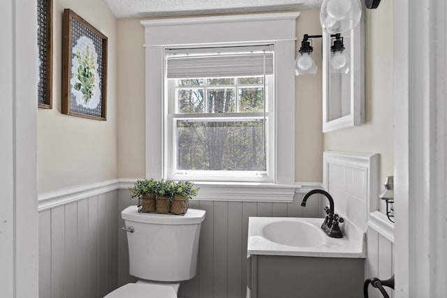 294 E Pond Rd, Jefferson, ME 04348 - half bathroom featuring wainscoting, toilet, and vanity