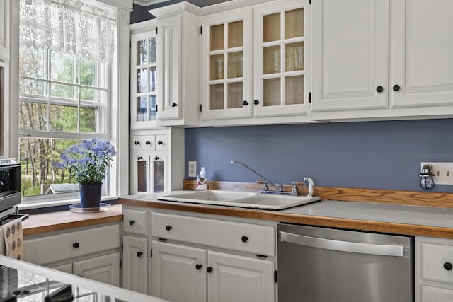 294 E Pond Rd, Jefferson, ME 04348 - kitchen with stainless steel dishwasher, white cabinetry, a sink, and glass insert cabinets