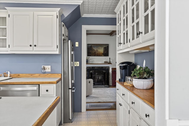 294 E Pond Rd, Jefferson, ME 04348 - kitchen featuring stainless steel appliances, ornamental molding, white cabinets, glass insert cabinets, and a fireplace with raised hearth
