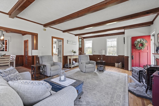 294 E Pond Rd, Jefferson, ME 04348 - living area with wood finished floors, beam ceiling, a wainscoted wall, and a textured ceiling