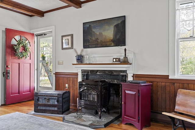 294 E Pond Rd, Jefferson, ME 04348 - living room featuring a wainscoted wall, beamed ceiling, a wood stove, wood finished floors, and wooden walls