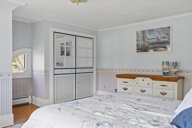 294 E Pond Rd, Jefferson, ME 04348 - bedroom with a baseboard heating unit, a wainscoted wall, wood finished floors, crown molding, and a textured ceiling