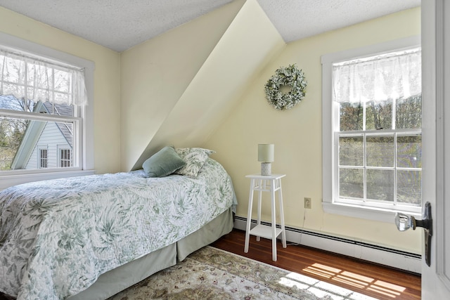 294 E Pond Rd, Jefferson, ME 04348 - bedroom featuring baseboard heating, wood finished floors, multiple windows, and a textured ceiling