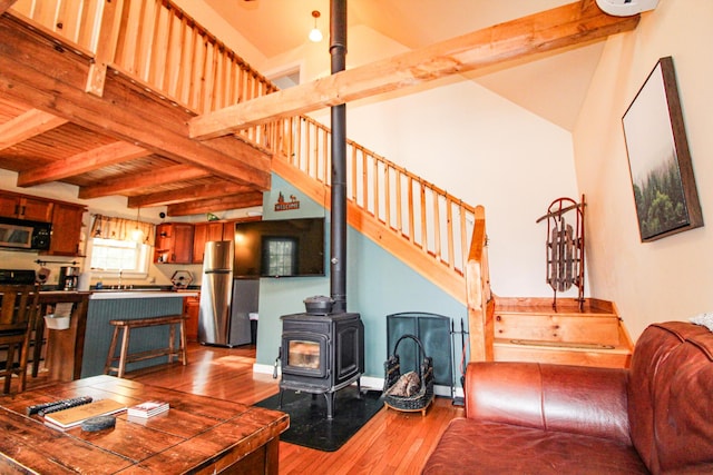 4 Bobs Way, Bethel, ME 04217 - living room featuring a wood stove, wood finished floors, and stairway