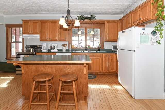 257 S Rumford Rd, Rumford, ME 04276 - kitchen featuring white appliances, an ornate ceiling, light wood-type flooring, under cabinet range hood, and ornamental molding
