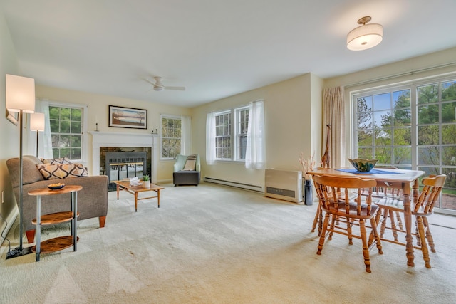 23 Winterberry Ct Unit 23, Cumberland, ME 04021 - dining area with a baseboard radiator, carpet, a ceiling fan, and a glass covered fireplace