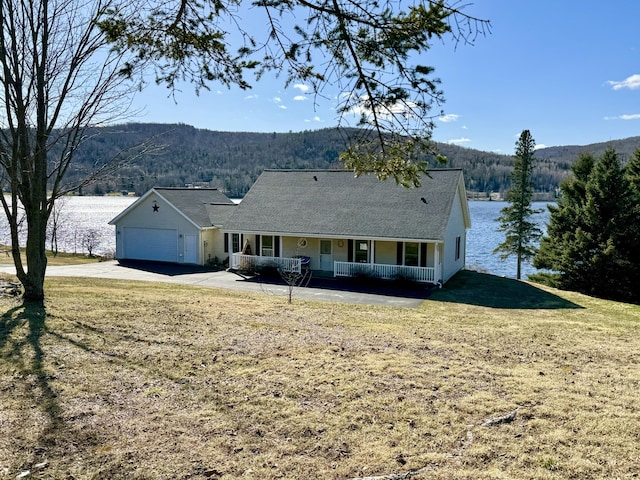 1379 Sly Brook Rd, Eagle Lake, ME 04739 - view of front of property with covered porch, a forest view, a front yard, an attached garage, and driveway