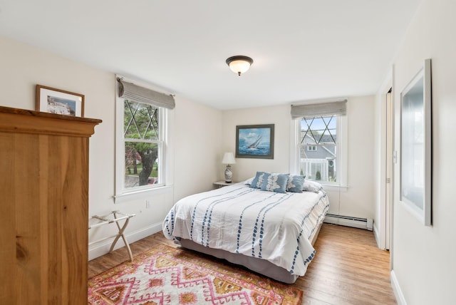 1081 Kings Hwy, Kennebunkport, ME 04046 - bedroom featuring multiple windows, a baseboard radiator, and wood finished floors