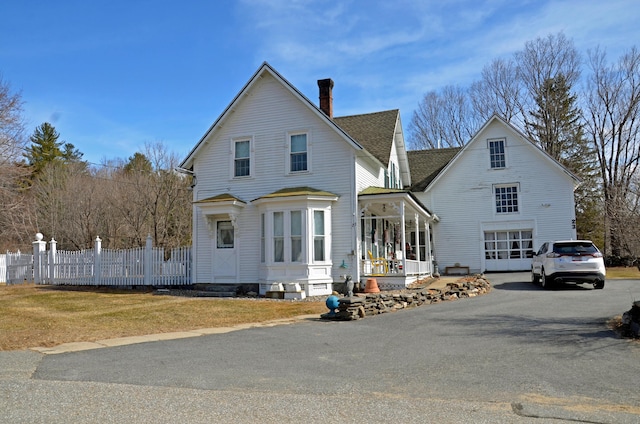 23 Park St, West Paris, ME 04289 - view of front of property with fence, aphalt driveway, covered porch, a garage, and a chimney
