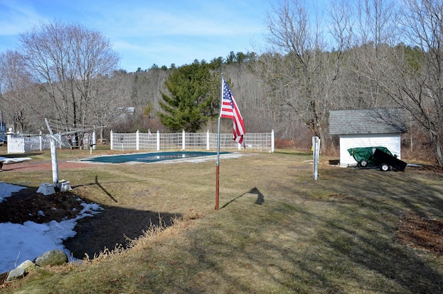 23 Park St, West Paris, ME 04289 - view of yard featuring an outdoor structure, a view of trees, a storage unit, and fence