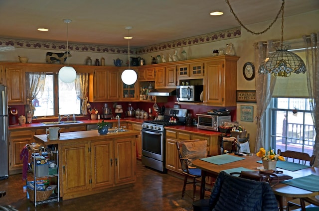 23 Park St, West Paris, ME 04289 - kitchen featuring an island with sink, a sink, under cabinet range hood, stainless steel appliances, and decorative light fixtures
