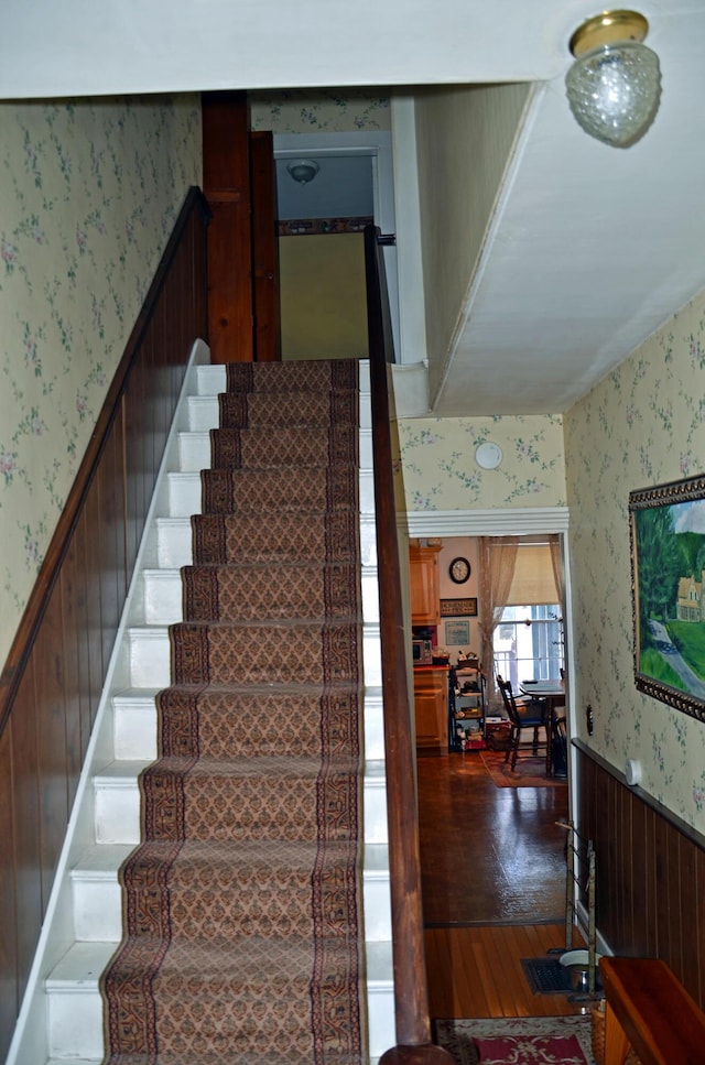 23 Park St, West Paris, ME 04289 - stairs with wallpapered walls, wainscoting, and wood finished floors