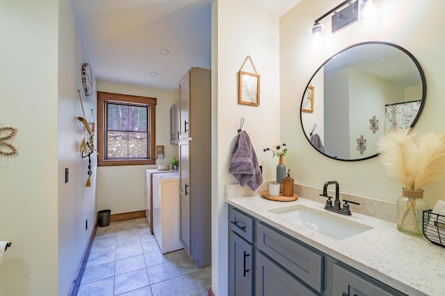 full bathroom featuring washer / clothes dryer, tile patterned floors, vanity, and baseboards